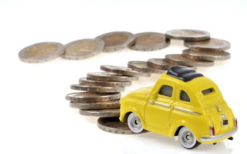 Igračka automobil prelazi preko kovanica